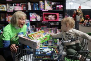 Woman volunteering with child, gifting toys